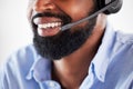 Closeup of one happy african american call centre telemarketing agent with big smile talking on headset while working in Royalty Free Stock Photo