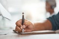 Closeup of one mixed race businessman writing notes in a book while working in at a desk in an office. Hands of Royalty Free Stock Photo