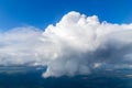 Closeup of one single big white cloud on the right side, in the clear deep blue sky, on a sunny day Royalty Free Stock Photo