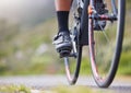 Closeup of one woman cycling outside. Sporty fit female athlete with her feet on bicycle pedals while riding a bike on a Royalty Free Stock Photo