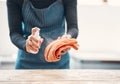 Closeup of one woman spraying antibacterial cleaner from a bottle onto a cloth to disinfect and wipe table in a cafe or