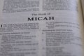 Closeup of an open page of the book of micah with partly blurred text
