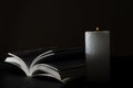 Closeup of opened Bible and candle flame against black background Royalty Free Stock Photo