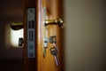 Closeup opened brown wooden door with handle and keys