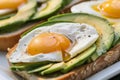 closeup of an openface sandwich with sliced avocado and egg