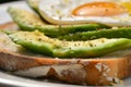 closeup of an openface sandwich with sliced avocado and egg