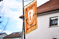 Closeup of an orange flag on a pole on the street during the Fasching carnival parade in Germany