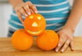 Closeup on orange with funny face in hand of woman Royalty Free Stock Photo