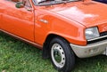 Closeup of orange historic Renault 5 car during an exhibition in a park