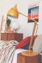 Closeup of orange lamp on bedside table in vintage bedroom, real photo