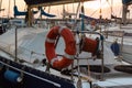 Closeup of Orange Lifebuoy and Rolled Rope on Sailing Boat Royalty Free Stock Photo