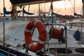 Closeup of Orange Lifebuoy and Rolled Rope on Sailing Boat Royalty Free Stock Photo