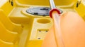 Closeup of orange paddle and blurry yellow kayak