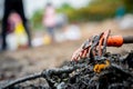 Closeup orange rake on pile of dirty waste on blurred background of volunteer clean up beach. Beach environmental pollution Royalty Free Stock Photo