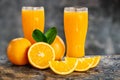 Orange sliced and orange juice glasses with green leaf on wooden table Royalty Free Stock Photo