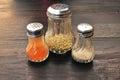 Closeup of oregano, pepper and chilli bottles on w
