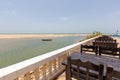 Closeup of an outdoor cafe in Senegal with the sea and a boat on the background under a blue sky