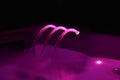 Closeup of an outdoor hot tub with pink lighting during nighttime Royalty Free Stock Photo