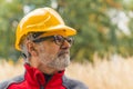 Closeup outdoor portrait of caucasian man in his 60s with gray facial hair and black glasses focusing on his work and Royalty Free Stock Photo