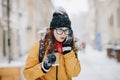 Closeup outdoor portrait of cute happy Caucasian teenage girl with takeaway coffee talking on smartphone Royalty Free Stock Photo