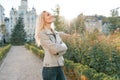 Closeup outdoor portrait of young smiling blond woman with long curly hair. On city street sunny day Royalty Free Stock Photo