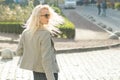 Closeup outdoor portrait of a young smiling blond woman with sunglasses with long curly hair. On city street sunny day Royalty Free Stock Photo