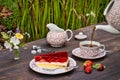 Closeup of the outdoor tea table with a piece of strawberry jello cake.