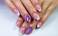 Closeup of oval-shaped nails with a french manicure and colorful design