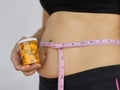 Closeup of overweight fat woman taking slimming pills from bottle Royalty Free Stock Photo