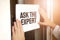 Closeup of owner holding Ask the Expert sign in store Royalty Free Stock Photo