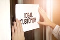 Closeup of owner holding text IDEAL CUSTOMER in store Royalty Free Stock Photo