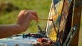 Painter hand drawing oil paints outdoor. Unknown artist painting canvas closeup Royalty Free Stock Photo