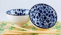 Two delicate leaf pattern china bowls and chopsticks.