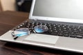 Closeup pair of glasses on the laptop keyboard