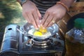 Closeup of a pair of hands cracking an egg into a pan