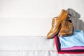 Closeup of Pair of Male Full Brogued Tan Oxford Shoes Placed on Top of Heap Of Colorful Clothing