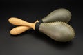 A pair of rawhide maracas lying on a black underground Royalty Free Stock Photo