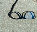 Closeup of a pair of scuffed broken glasses on the ground Royalty Free Stock Photo