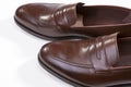 Closeup of Pair of Stylish Brown Penny Loafer Shoes Against White