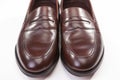 Closeup of Pair of Stylish Brown Penny Loafer Shoes On White