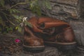 Closeup of pair of worn working or cowboy boots set on stone wall
