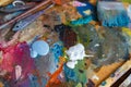 Closeup palette with paintbrush and palette-knife at studio or home background.