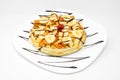 Closeup of a pancake with bananas, peach, chocolate syrups and cheery on top Royalty Free Stock Photo