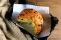 Closeup panetone inside box on wooden table, towel next