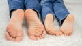 CLoseup of parent and child moving on floor at home and moving bare feet. Family having fun and playing together Royalty Free Stock Photo