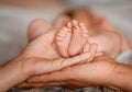 Closeup of parents hands holding newborn baby feet with wedding rings. The concept of the family. Black and white. Royalty Free Stock Photo