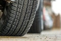 Closeup of parked car on a city street side with new winter rubber tires Royalty Free Stock Photo