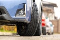 Closeup of parked car on a city street side with new winter rubber tires Royalty Free Stock Photo