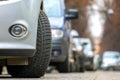 Closeup of parked car on a city street side with new winter rubber tires Royalty Free Stock Photo