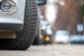 Closeup of parked car on a city street side with new winter rubber tires Royalty Free Stock Photo